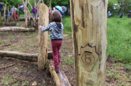 Een kind speelt in een houten speeltuin 