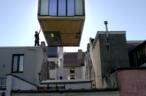 Een schuifhuis wordt tussen twee huizen geplaats. 