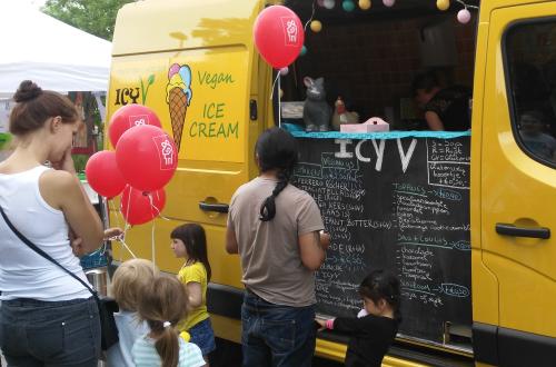 Een foodtruck met mensen die aanschuiven voor eten. 