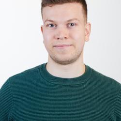 Een portretfoto van een jonge man met een groene pull. 