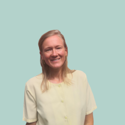 Een portretfoto van een witte vrouw met blond haar en een witte blouse.